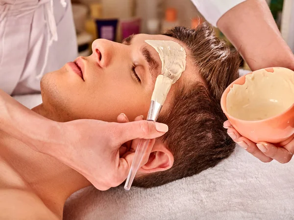 Máscara de barro de curación facial del hombre en el salón de spa . —  Fotos de Stock
