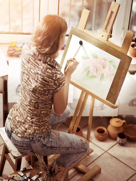 Pintura de artista em cavalete no estúdio. Pinturas menina com escova . — Fotografia de Stock
