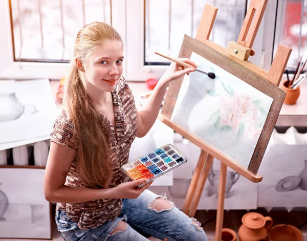 Pintura de artista em cavalete no estúdio. Pinturas menina com escova . — Fotografia de Stock