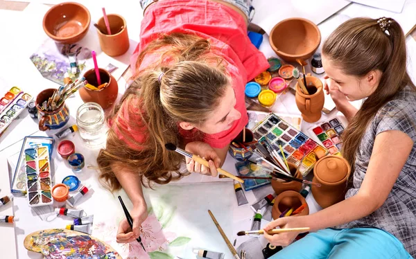 Hiteles művész gyermek lány festékek a padlón. Szemközti nézet. — Stock Fotó
