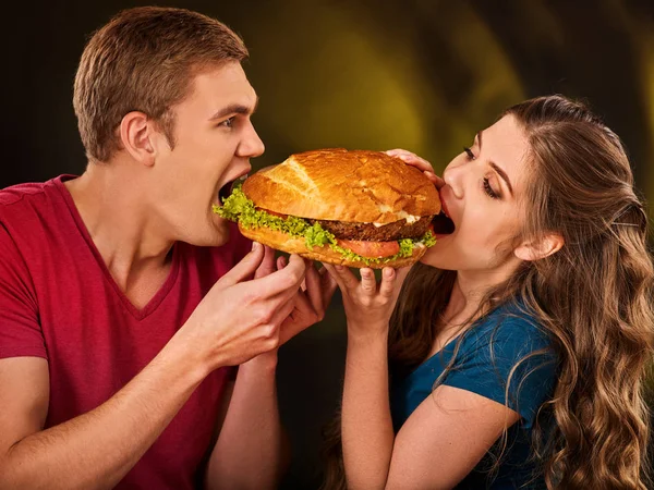 Pár gyors étkezés. Férfi és nő kezelésére hamburger . — Stock Fotó
