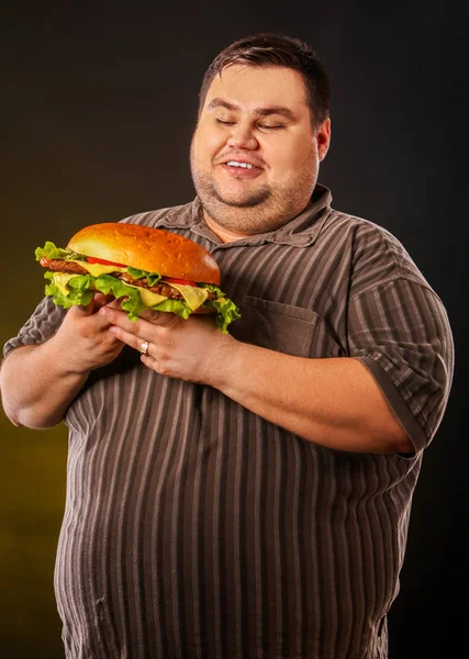 Pria gemuk makan hamberger makanan cepat saji. Sarapan untuk orang kelebihan berat badan . — Stok Foto