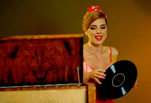 Retro kvinna med musik vinylskiva. Flicka pin-up stil iklädd röd klänning. — Stockfoto