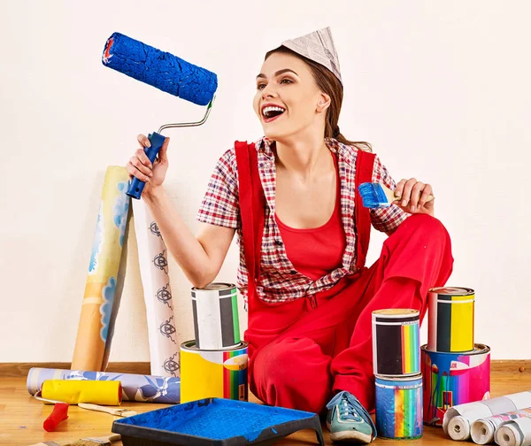 Reparera hem kvinna som håller paint roller för tapet. — Stockfoto