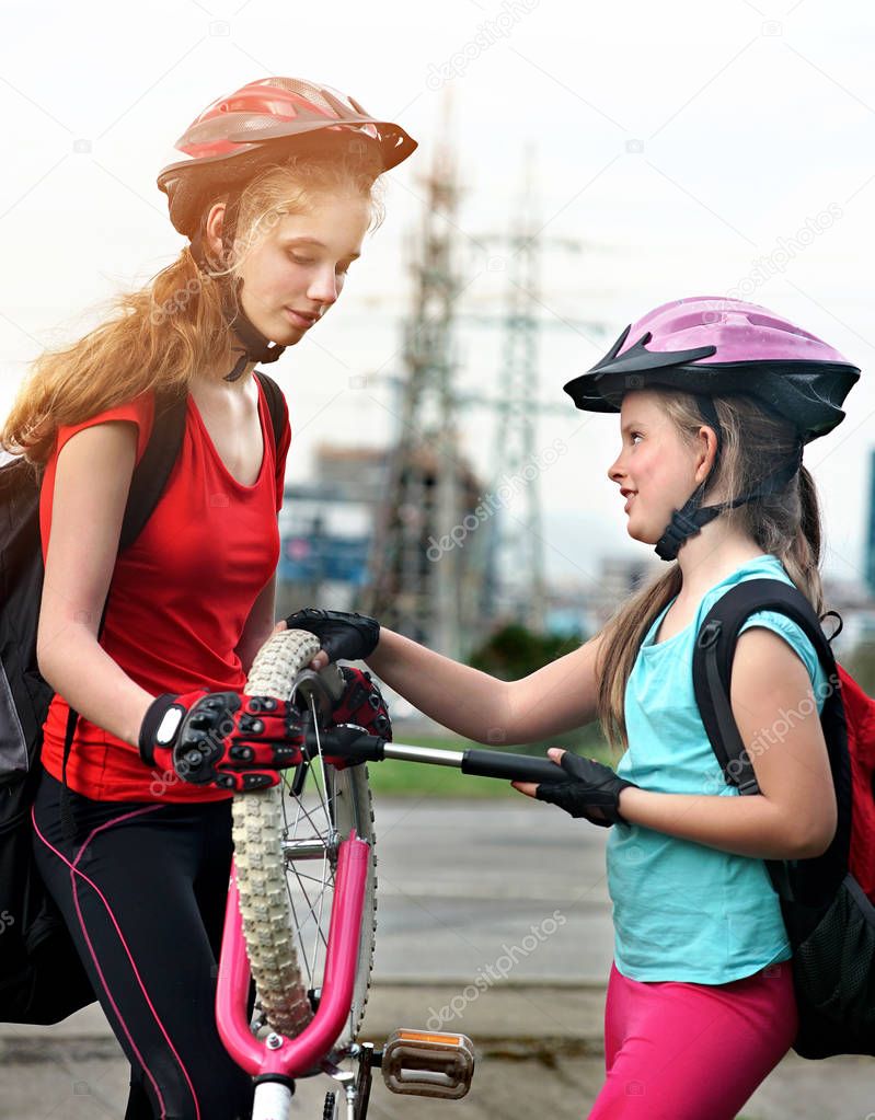 Girls children cycling family pump up bicycle tire.