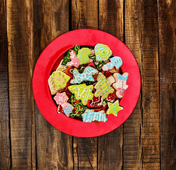 Christmas gingerbread cookies on red Xmas plate — Stock Photo, Image