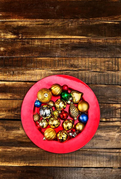 Χριστουγεννιάτικα στολίδια διακόσμηση του Χριστούγεννα μπάλες στολίδια σε κόκκινο πιάτο — Φωτογραφία Αρχείου