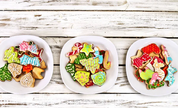 Galletas de jengibre de Navidad en tres platos por mesa de madera — Foto de Stock