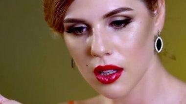 Ruj kırmızı dudakları boyayan kadının elinde..