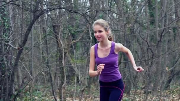 Woman runner is jogging on forest path in park. — Stock Video