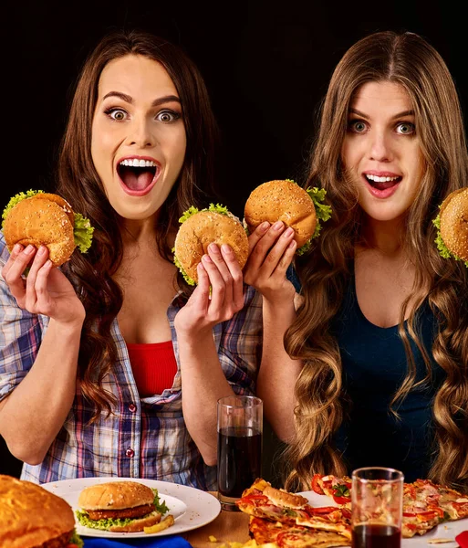 Mulheres do grupo comem melhor hambúrguer e pizza no bar de hambúrgueres — Fotografia de Stock
