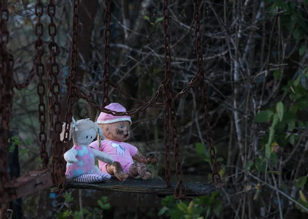 Abandonado criança boneca e brinquedo macio no balanço — Fotografia de Stock