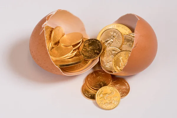 Monedas de oro puro en cáscara de huevo que ilustran el huevo nido —  Fotos de Stock