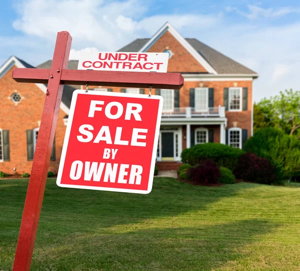 For sale sign in front of large USA home