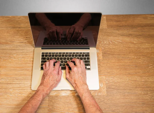 Üst düzey yetişkin erkek elini türleri üstünde laptop — Stok fotoğraf