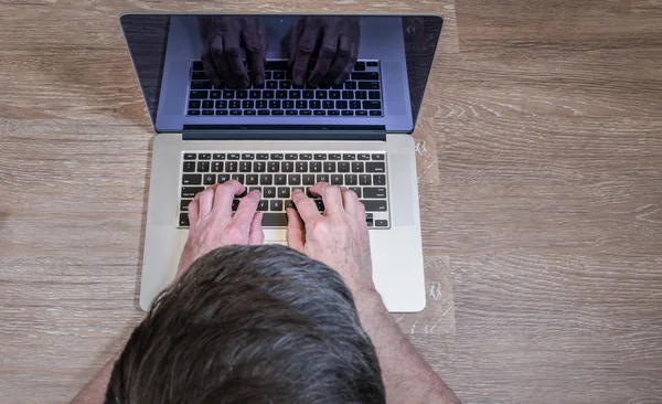 Senior adult man touch types on laptop — Stock Photo, Image