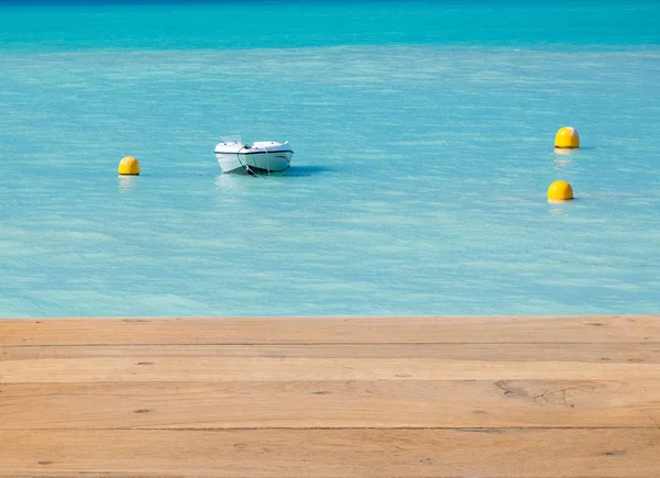 木製のデッキを離れて穏やかな海でボート — ストック写真