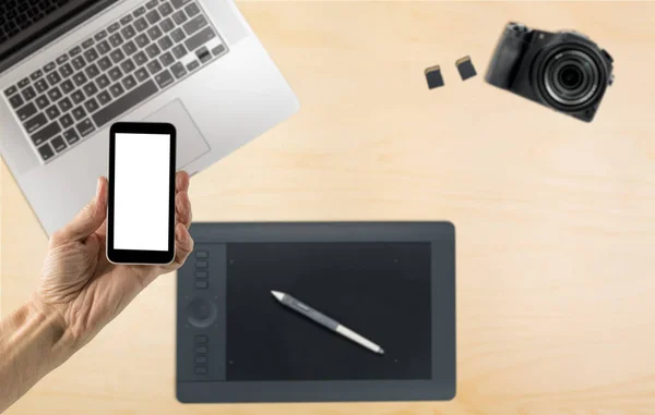 Smartphone a mano con schermo bianco sulla scrivania — Foto Stock