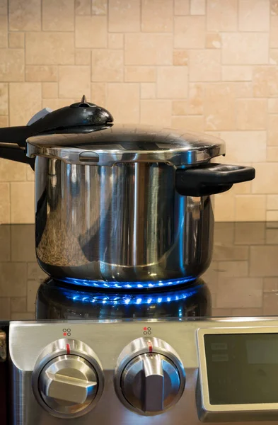 Stainless steel pressure cooker on hob — Stock Photo, Image