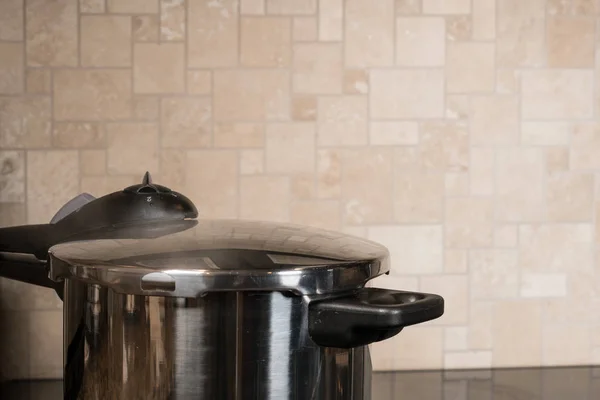 Stainless steel pressure cooker on hob — Stock Photo, Image