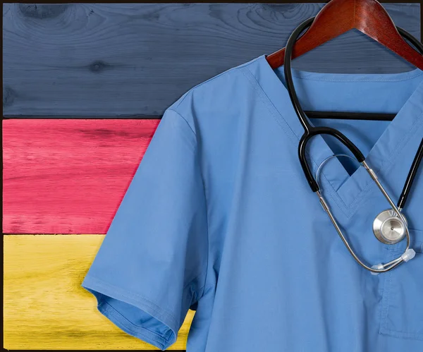 A Németország lobogója alatt a bevándorló egészségügyi kék scrubs — Stock Fotó
