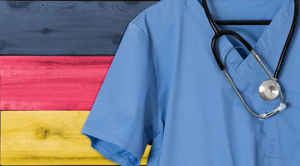 A Németország lobogója alatt a bevándorló egészségügyi kék scrubs — Stock Fotó