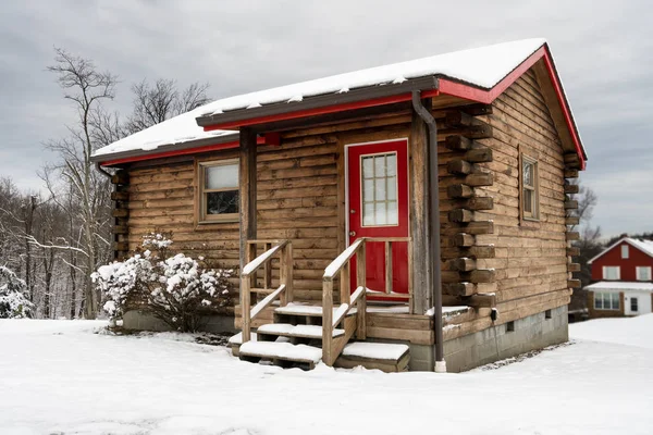 Pequena cabine de madeira espaçosa na neve no inverno — Fotografia de Stock