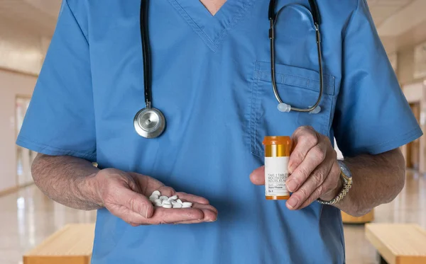 Senior doctor in scrubs with RX tablets — Stock Photo, Image