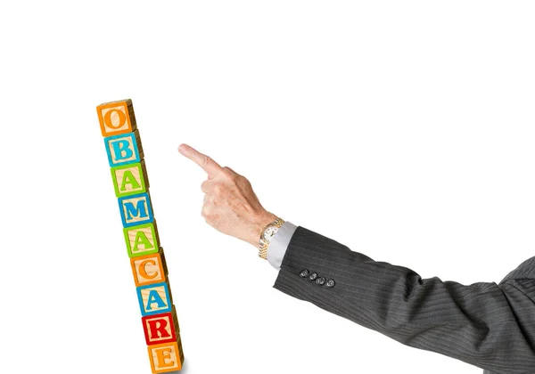 Senior man hand pushing obamacare blocks over — Stock Photo, Image