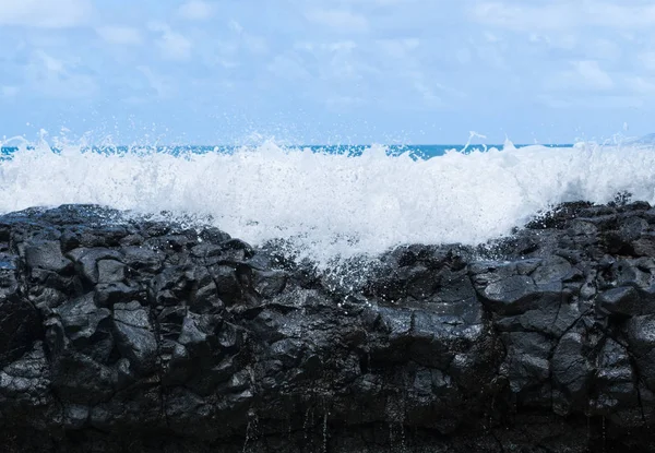 Frozen motion of ocean waterfall over rocks at Lumahai Beach — Stock Photo, Image