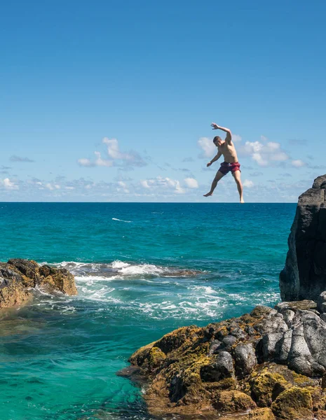 Alkalmas fiatal férfi ugrik a Lumahai strandon Kauai óceán — Stock Fotó