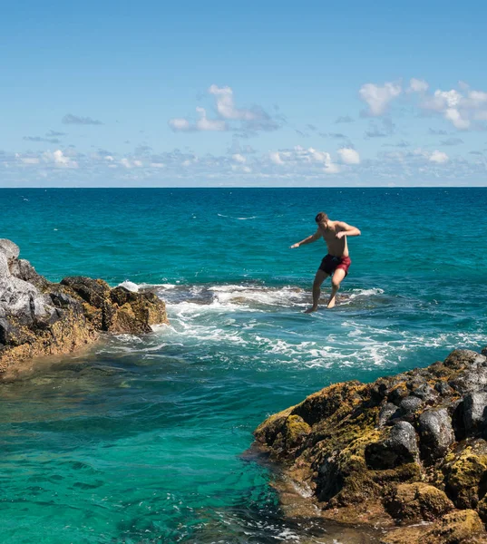 In forma giovane uomo salta nell'oceano a Lumahai spiaggia Kauai — Foto Stock