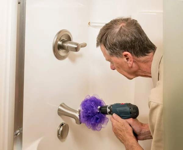 Senior homme nettoyage d'une douche avec perceuse électrique — Photo