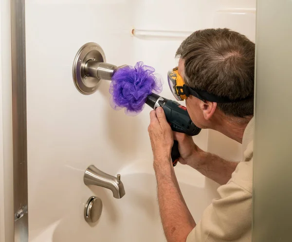 Hombre mayor limpiando una ducha con taladro eléctrico — Foto de Stock