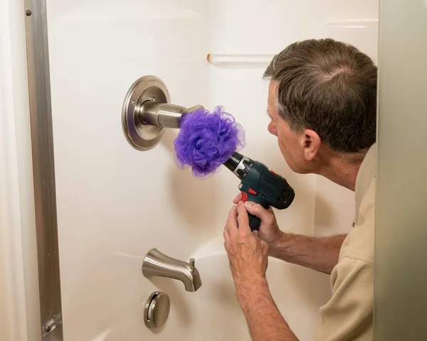 Senior homme nettoyage d'une douche avec perceuse électrique — Photo
