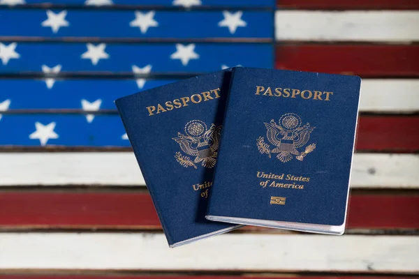 Pasaportes de Estados Unidos sobre mesa de vidrio sobre bandera de Estados Unidos —  Fotos de Stock