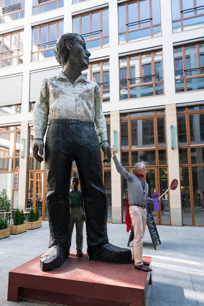 Reiseleiter mit Statue des großen und kleinen Mannes im Bareingang — Stockfoto