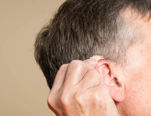 Крупним планом крихітний сучасний слуховий апарат за вухом — стокове фото
