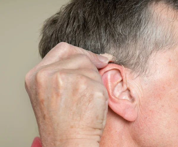 Close up of a tiny modern hearing aid behind ear — Stock Photo, Image