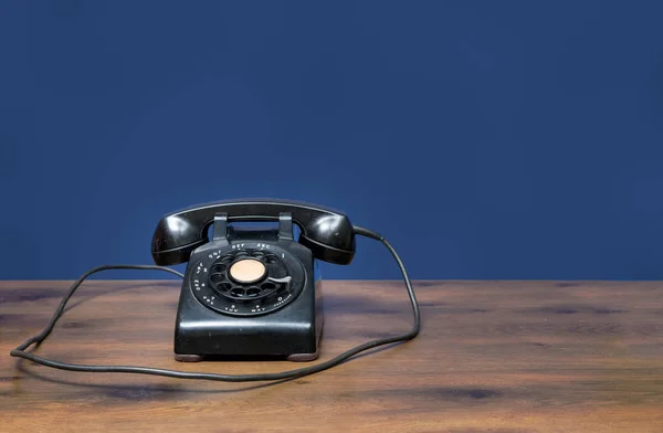 Antigo telefone de discagem rotativa na mesa de madeira — Fotografia de Stock