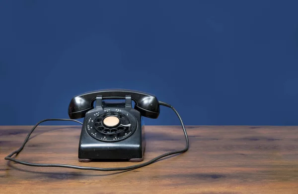 Antiguo teléfono de línea giratoria en escritorio de madera — Foto de Stock