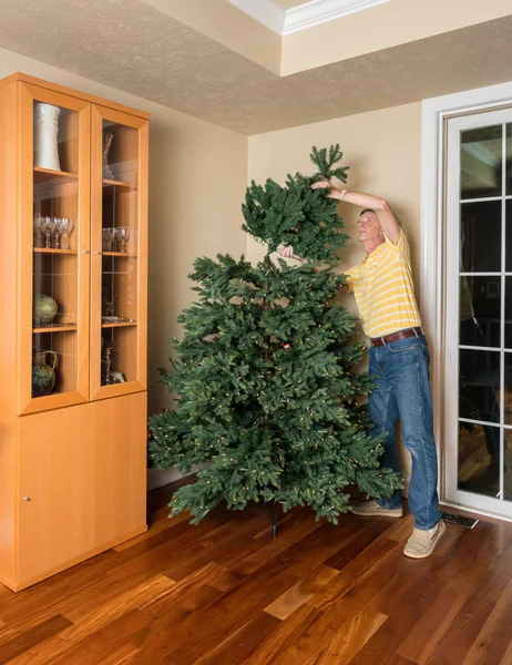 Senior mannen sätta konstgjord julgran tillsammans för Xmas — Stockfoto