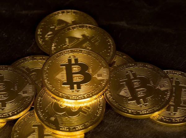 กองของ bitcoins กับพื้นหลังกระดานชนวน — ภาพถ่ายสต็อก