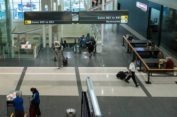 Los pasajeros entran en la terminal del aeropuerto para llegar a las puertas —  Fotos de Stock