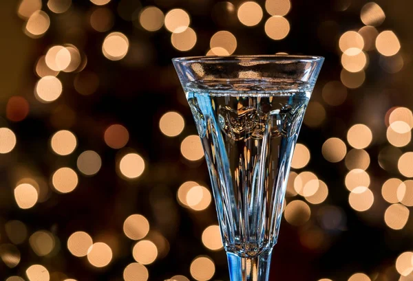 Champanhe em flauta de cristal contra as luzes da árvore de Natal — Fotografia de Stock