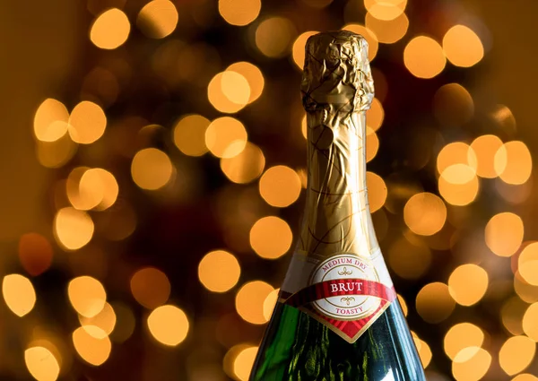 Tampo selado e cortiça de garrafa de champanhe contra árvore de Natal — Fotografia de Stock