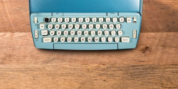 Old electric typewriter on wood background — Stock Photo, Image