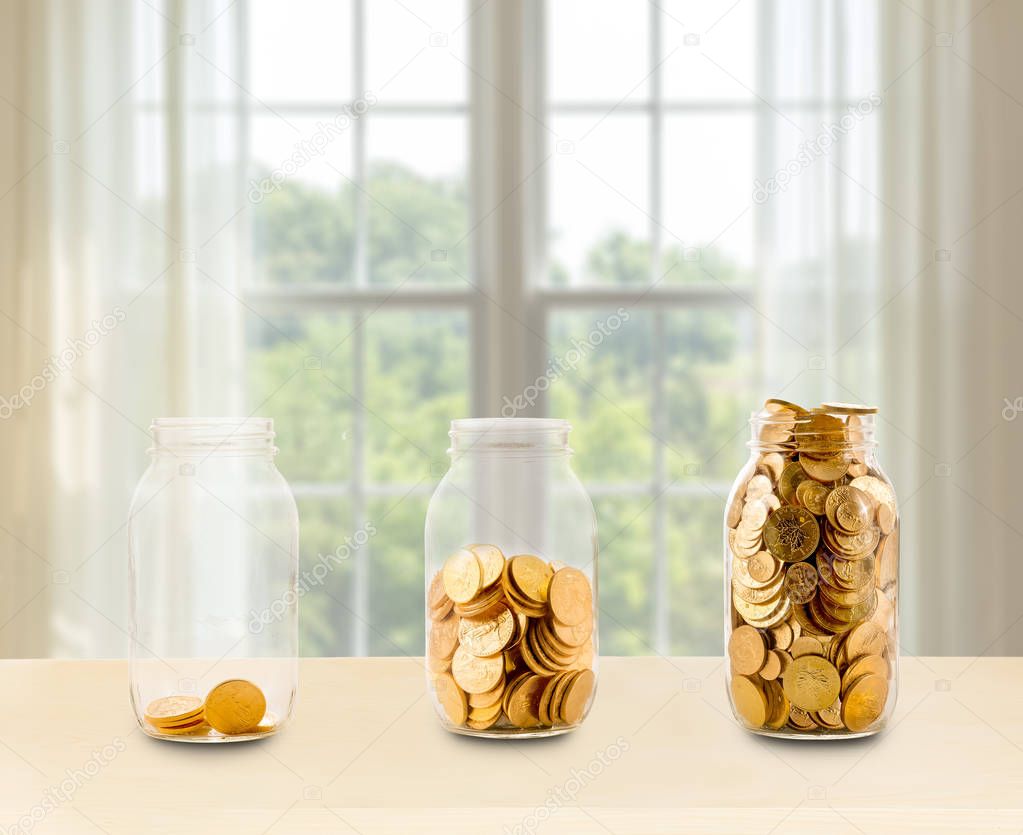 Three glass jars of growing savings on shelf