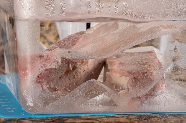 Два нью-йоркских стейка в ванне су виде
