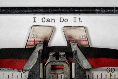 Macro of the ribbon and paper of typewriter with positive confident message clipart